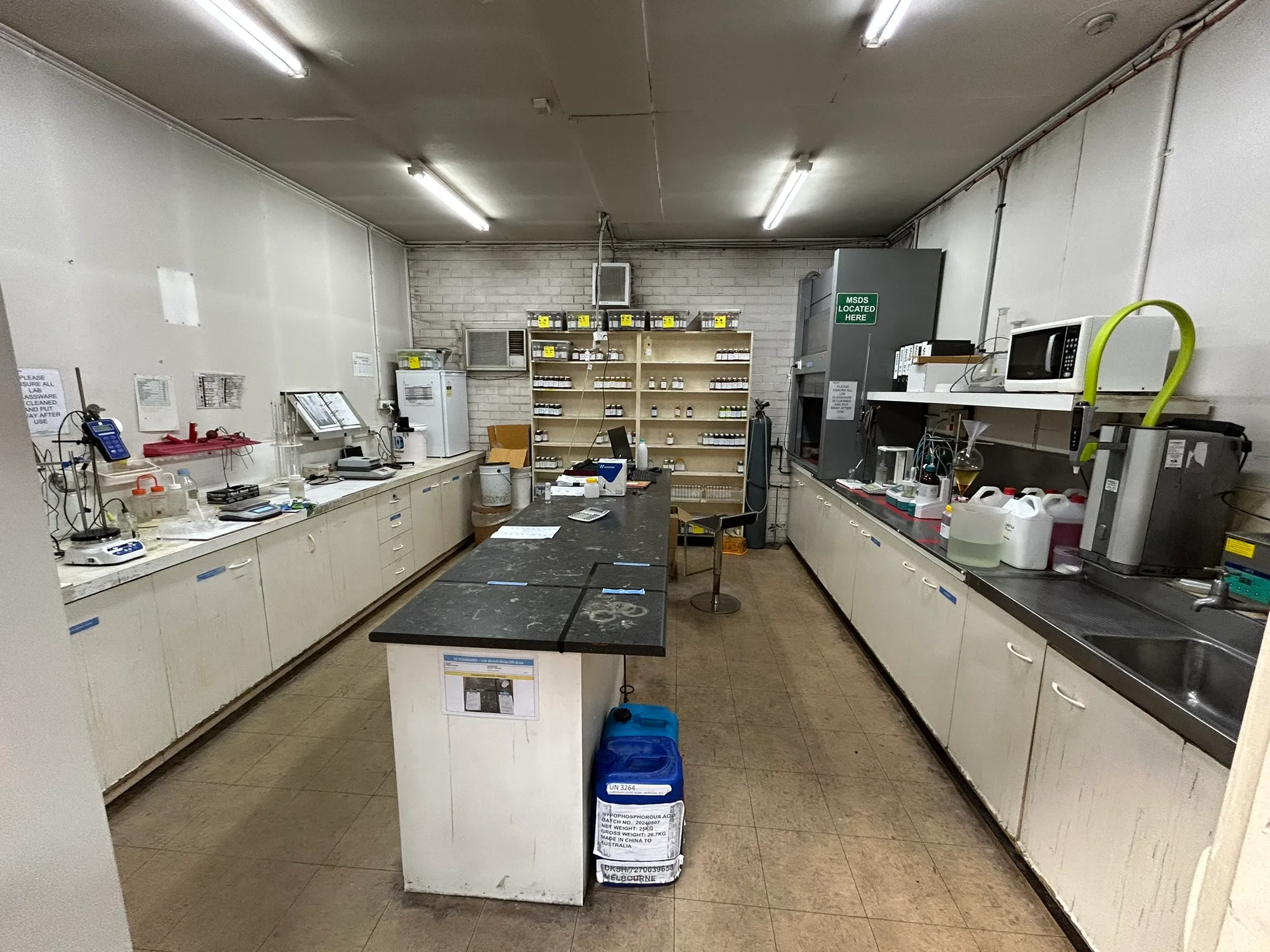 Tollman in-house laboratory — bench, reagent shelving, lab equipment