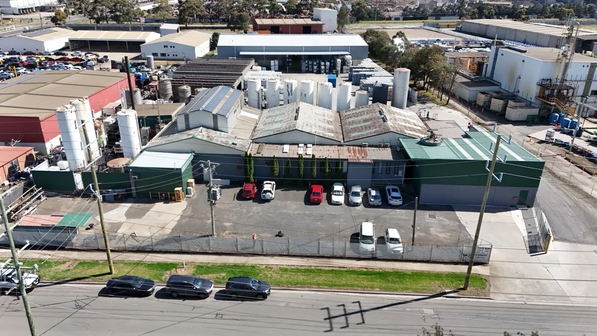 Aerial view of the Tollman premises in Laverton North — manufacturing buildings, bulk storage tanks, and yard
